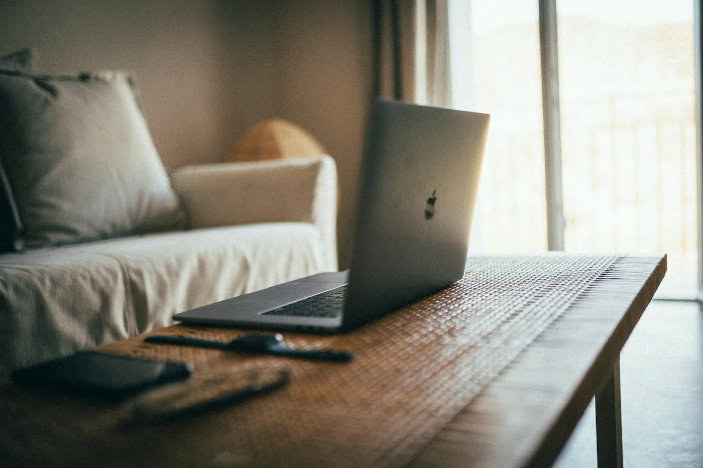 A calm living room with a sofa and laptop