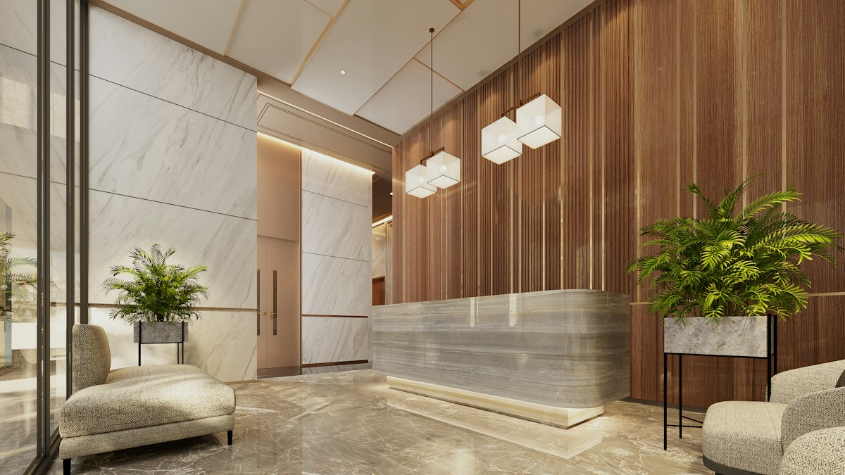 A bright office lobby with a reception desk and green plants